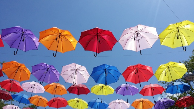Multi-coloured brollies against the clear blue sky